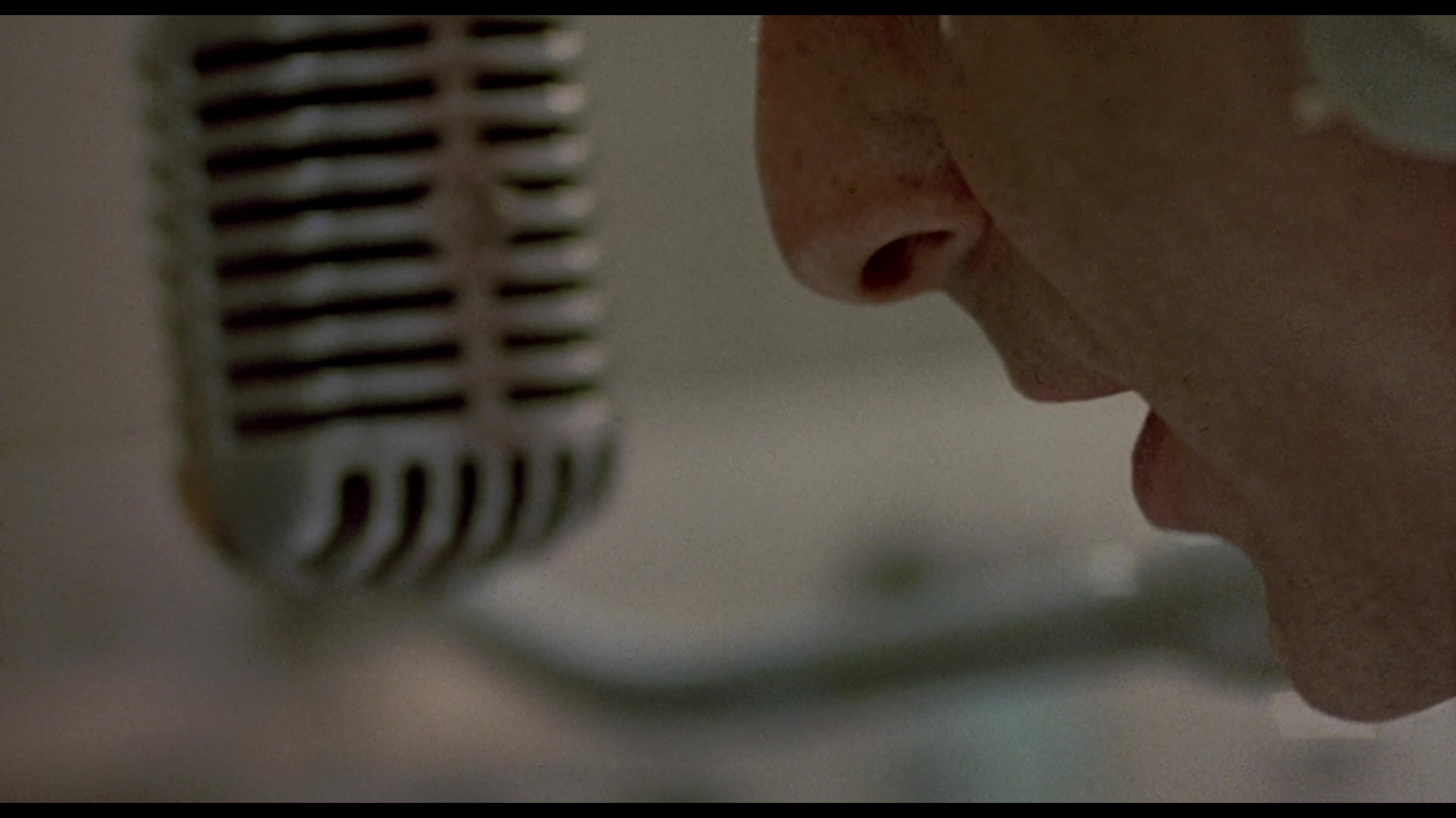 person speaking into old-fashioned mic 